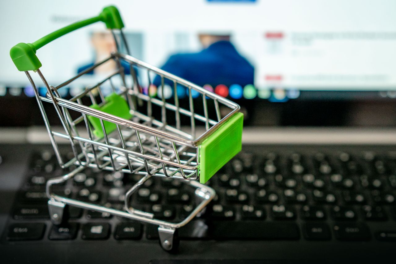 home-hero Miniature shopping cart placed on a laptop keyboard, symbolizing online shopping.